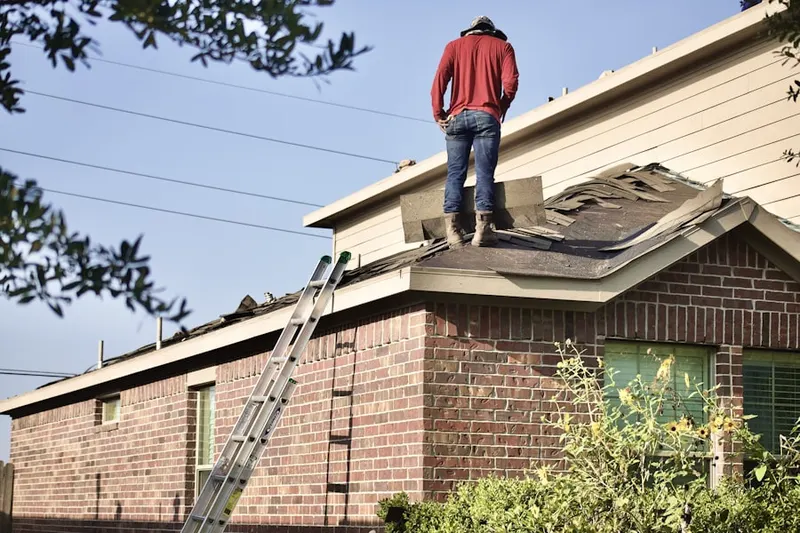 Professional roofer working on a residential roof in Greenfield